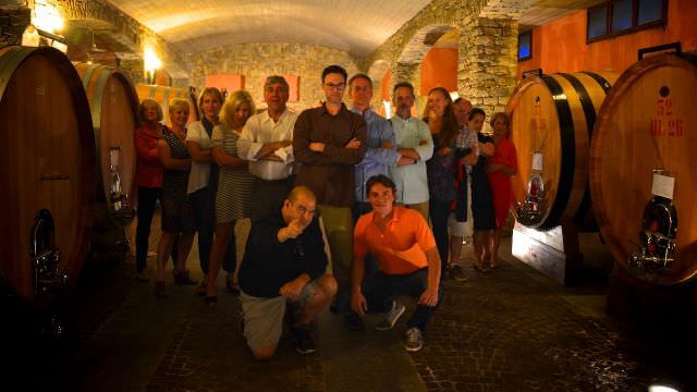 A group photo of everyone in a winery in Barolo, Italy. 
